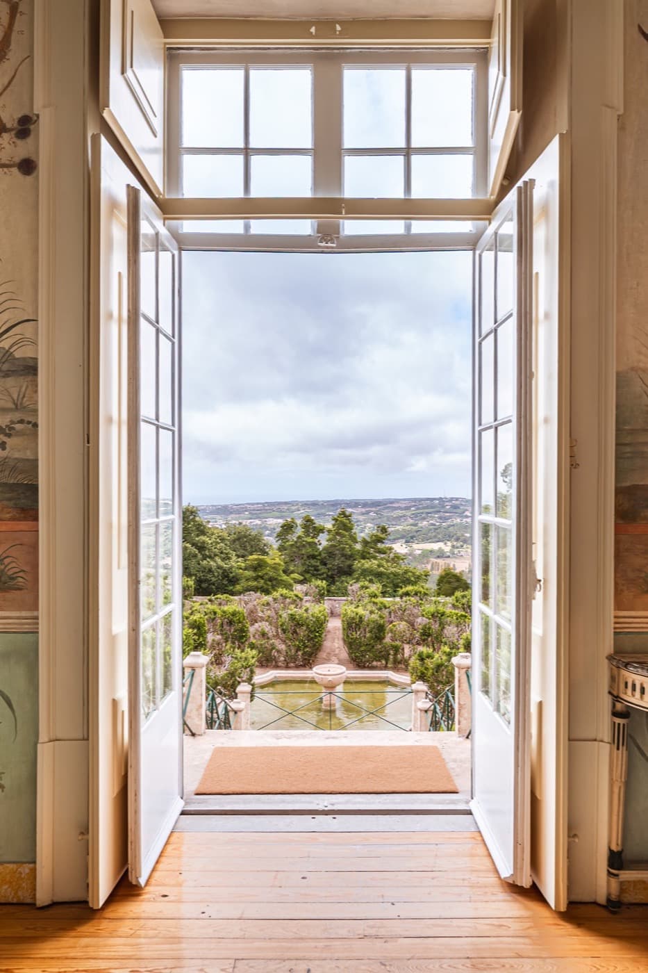 French doors open on the palace's axis, the garden and the plain beyond.