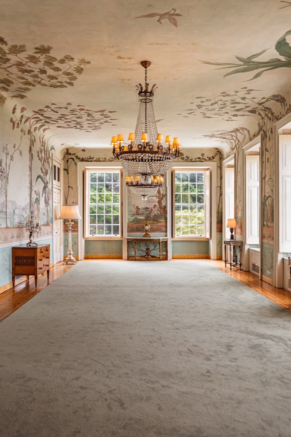 The frescoed salon down its centre line, chandelier over the console.